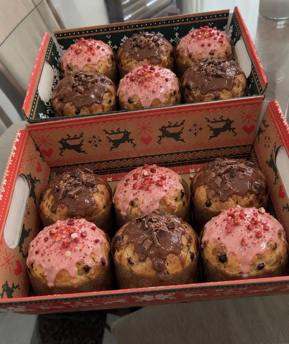 Mini panetones com cobertura de chocolate e morango em duas caixas natalinas